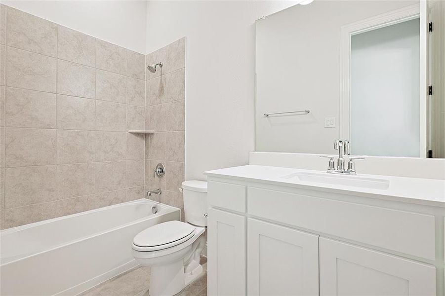 Full bathroom with toilet, tiled shower / bath, vanity, and tile patterned flooring