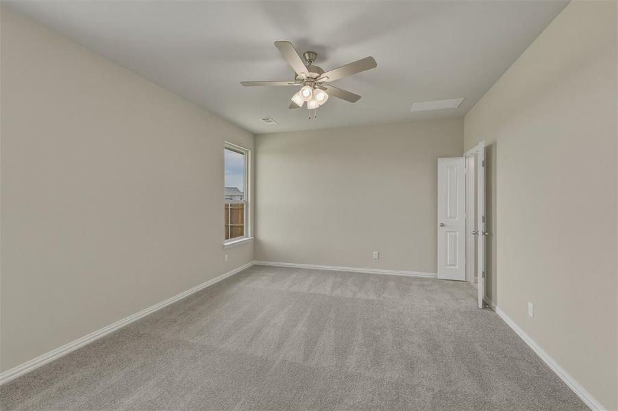 Carpeted room featuring a ceiling fan with integrated lighting, a single window, and a white paneled door Carpeted room featuring a ceiling fan with integrated lighting, a single window, and a white paneled door