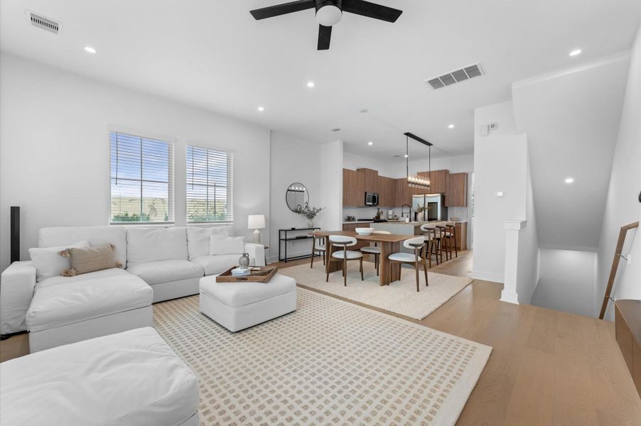 The second floor boasts a spacious open-concept living, dining, and kitchen area filled with natural light from abundant windows, featuring sleek modern finishes and warm engineered hardwood floors that create the perfect blend of style and comfort for everyday living and entertaining. The second floor boasts a spacious open-concept living, dining, and kitchen area filled with natural light from abundant windows, featuring sleek modern finishes and warm engineered hardwood floors that create the perfect blend of style and comfort for everyday living and entertaining.