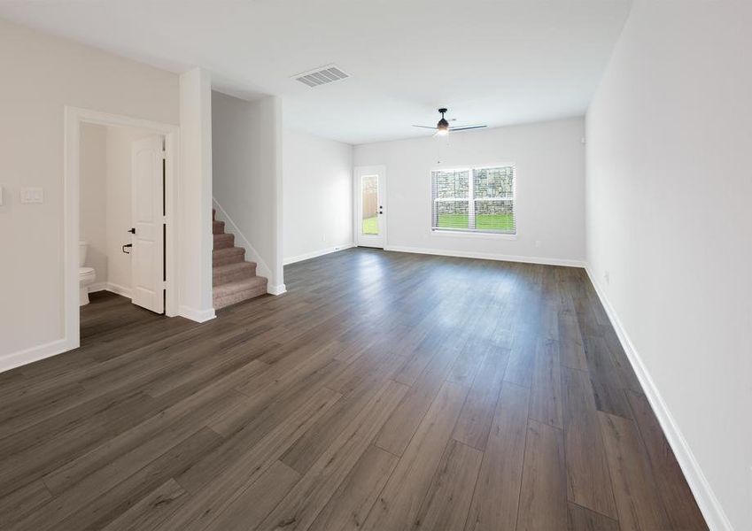 Spacious family room with plank flooring and ceiling fan