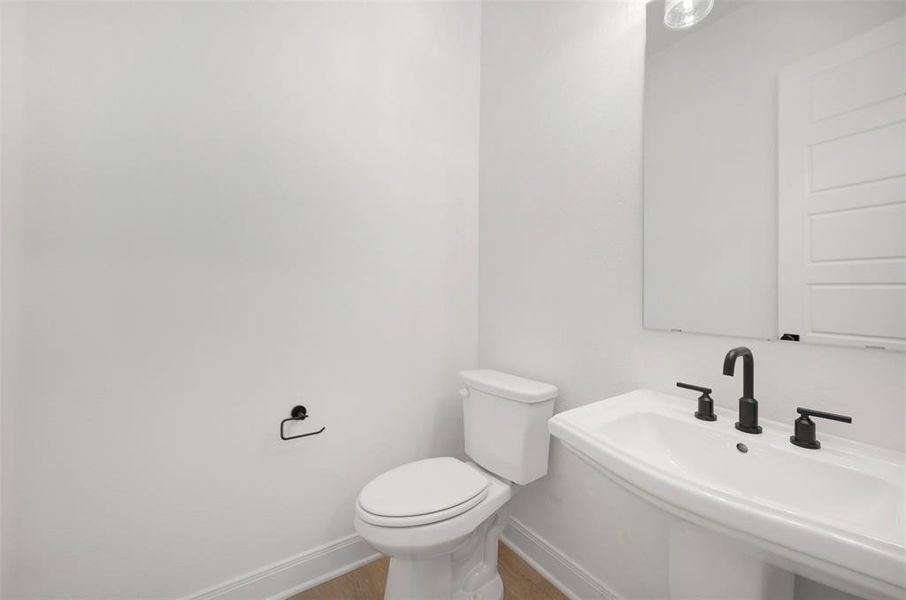 Half bath with baseboards and light wood finished floors