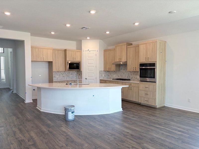 A contemporary culinary space with a gracefully curved island and sleek, integrated appliances. A contemporary culinary space with a gracefully curved island and sleek, integrated appliances.