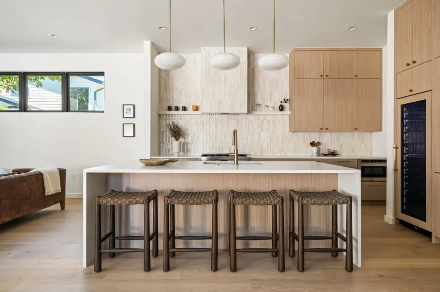 Clean lines and warm wood cabinetry define this modern kitchen with a waterfall island.