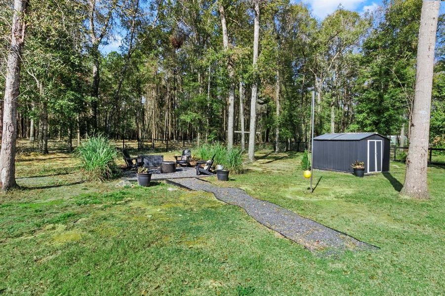 Beyond the guest home you will find the walkway to this quiet fire pit space. The storage shed is housing property equipment such as the well housing.