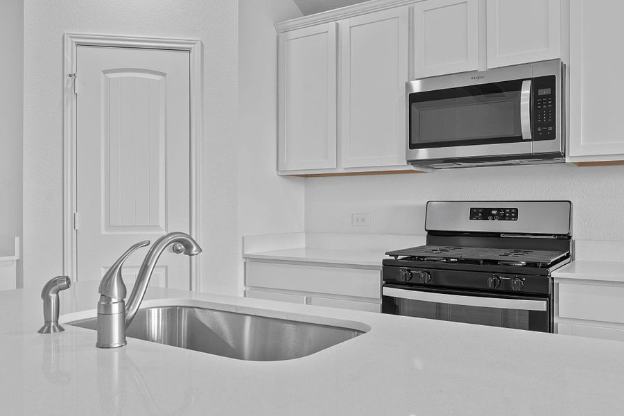 Kitchen with appliances with stainless steel finishes, white cabinets, and light stone countertops Kitchen with appliances with stainless steel finishes, white cabinets, and light stone countertops