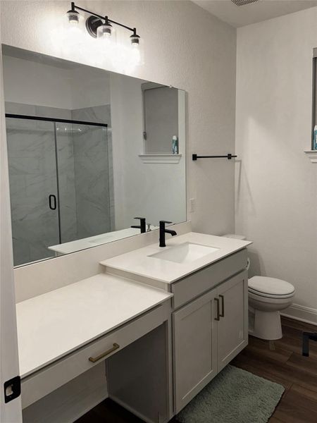 Bathroom vanity featuring a single sink, light-toned countertop, and built-in dressing table Bathroom vanity featuring a single sink, light-toned countertop, and built-in dressing table