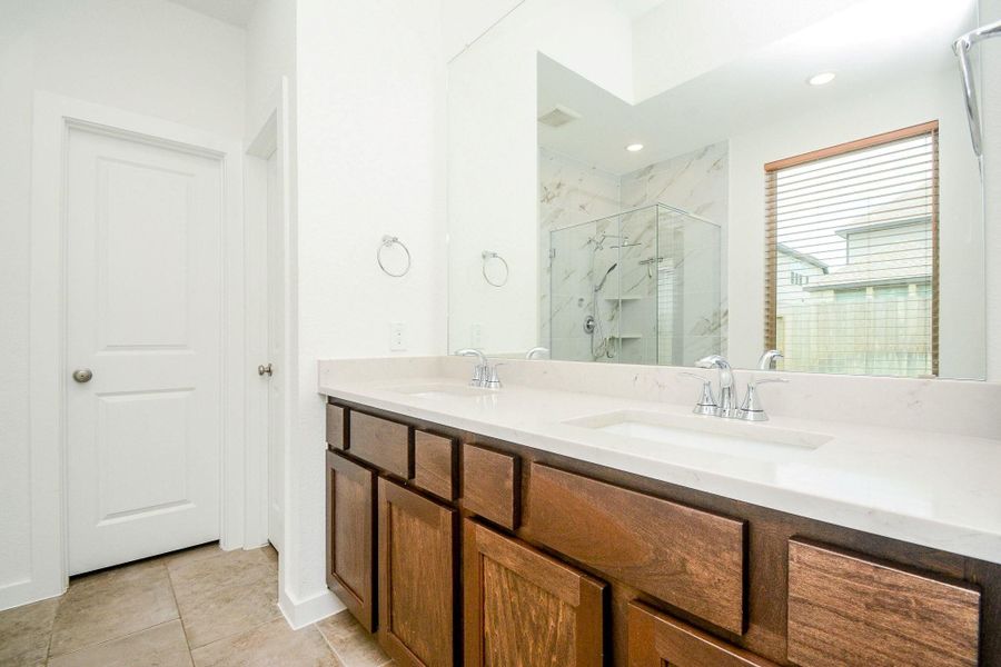 Luxurious primary bath featuring dual vanities and modern finishes. Luxurious primary bath featuring dual vanities and modern finishes.