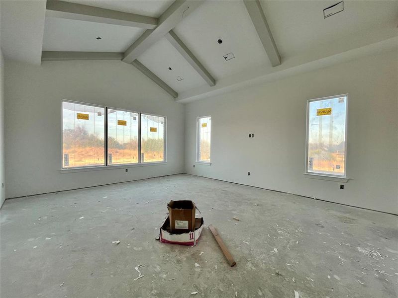 Spare room featuring beamed ceiling and high vaulted ceiling