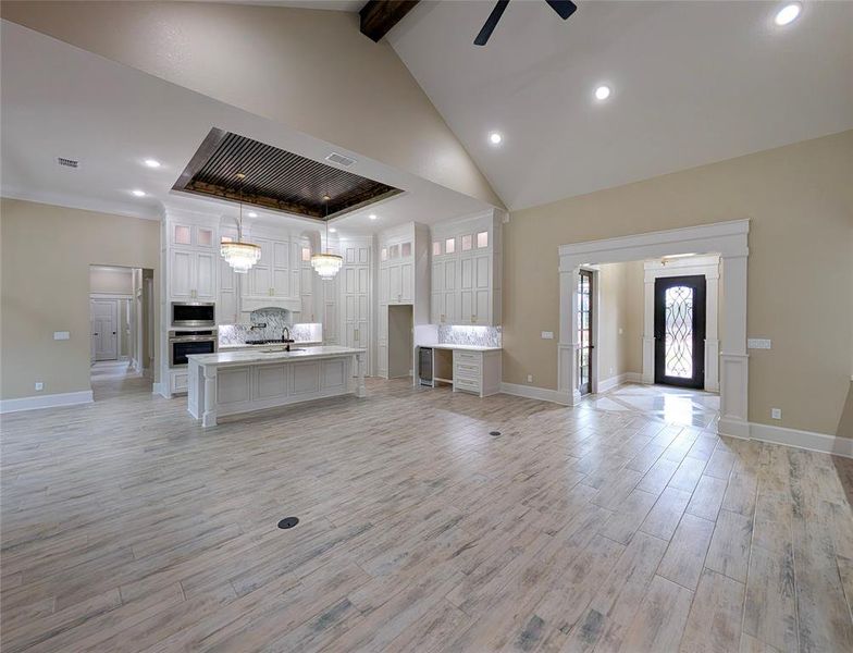 Living room with recessed lighting, wood finish floors, high vaulted ceiling, a ceiling fan, and beamed ceiling