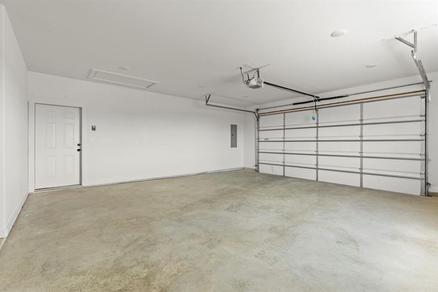 Garage featuring electric panel and a garage door opener