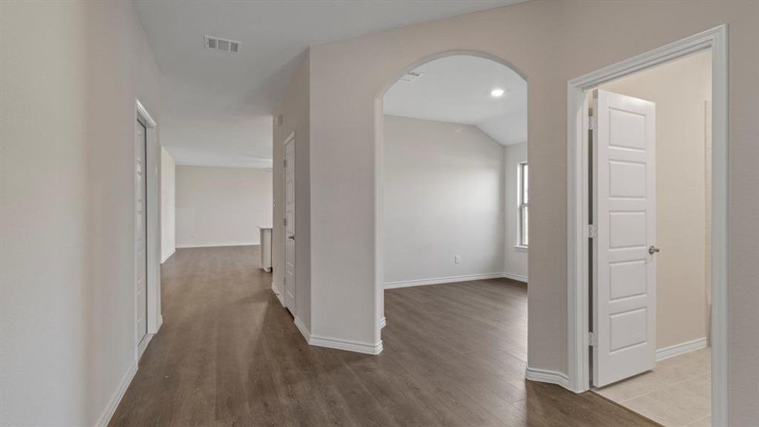 Hallway featuring arched walkways, wood finished floors, and recessed lighting Hallway featuring arched walkways, wood finished floors, and recessed lighting