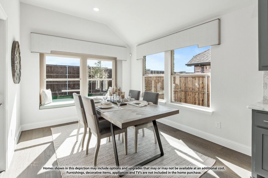 Bright dining area with gray wood table, four chairs, and large windows with backyard views Bright dining area with gray wood table, four chairs, and large windows with backyard views