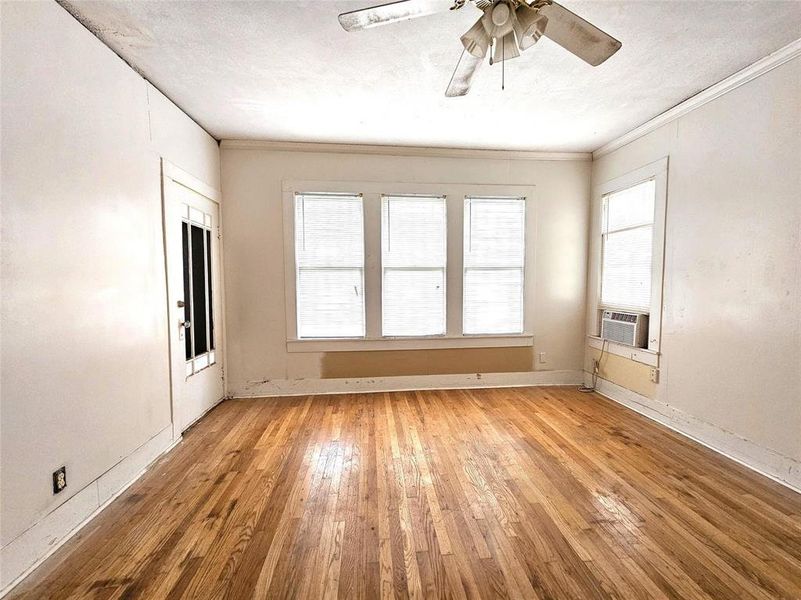 Spare room featuring ceiling fan, light hardwood / wood-style floors, plenty of natural light, and cooling unit Spare room featuring ceiling fan, light hardwood / wood-style floors, plenty of natural light, and cooling unit