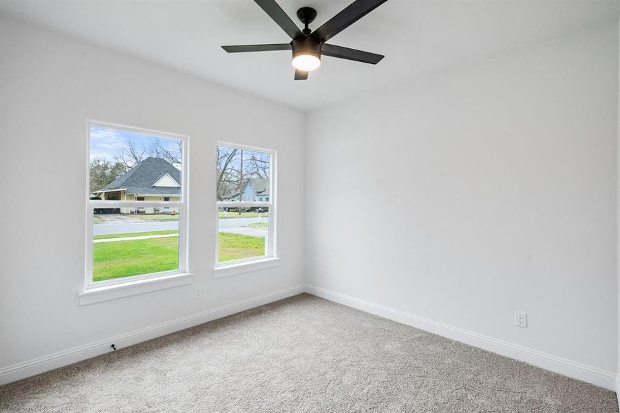 Empty room with carpet floors, baseboards, and a ceiling fan