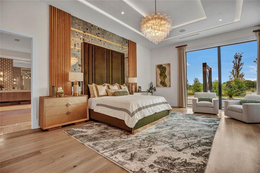 Bedroom featuring a chandelier, a tray ceiling, light wood-style flooring, and recessed lighting Bedroom featuring a chandelier, a tray ceiling, light wood-style flooring, and recessed lighting