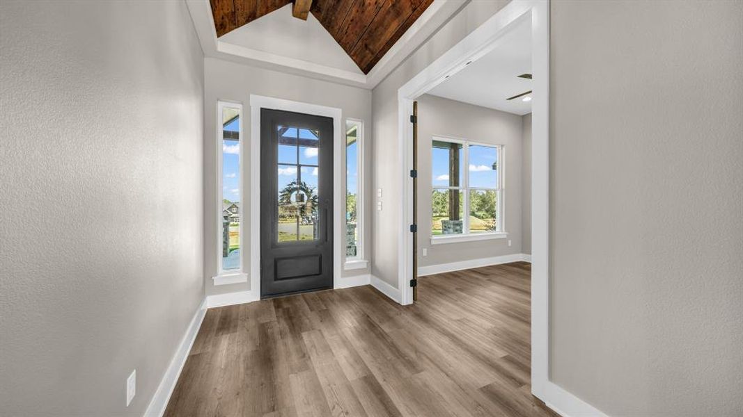 Entrance foyer featuring wood accent vaulted ceiling, and ceiling fan