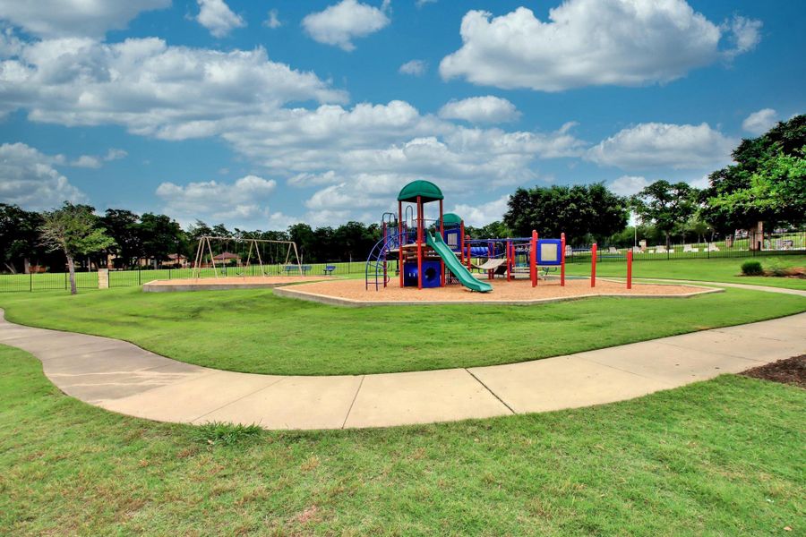 This outdoor space features a playground with slides and swings, set on a large lawn area