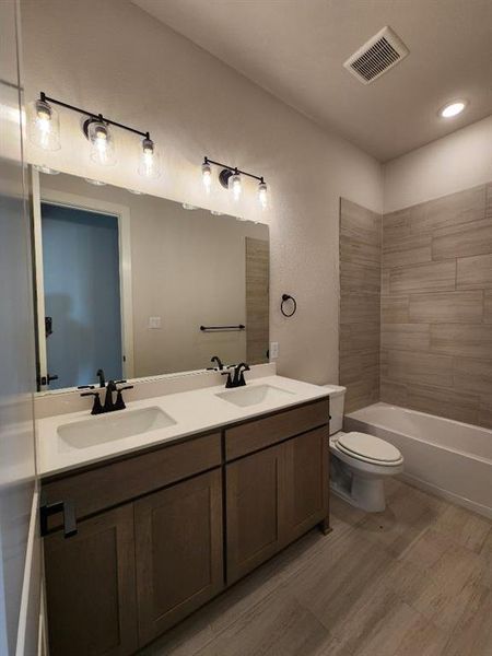 Bathroom featuring a double vanity with white countertops, dual undermount sinks, and matte black fixtures