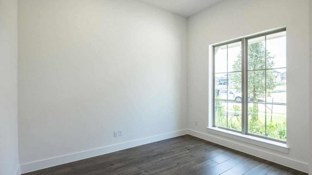 Spare room with baseboards and dark wood-style flooring Spare room with baseboards and dark wood-style flooring