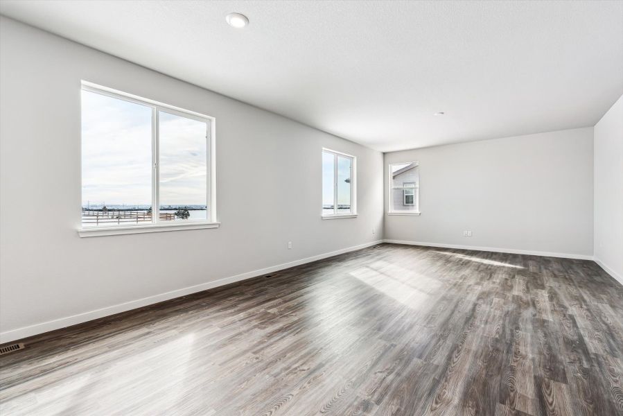 A room with a wood floor and windows.