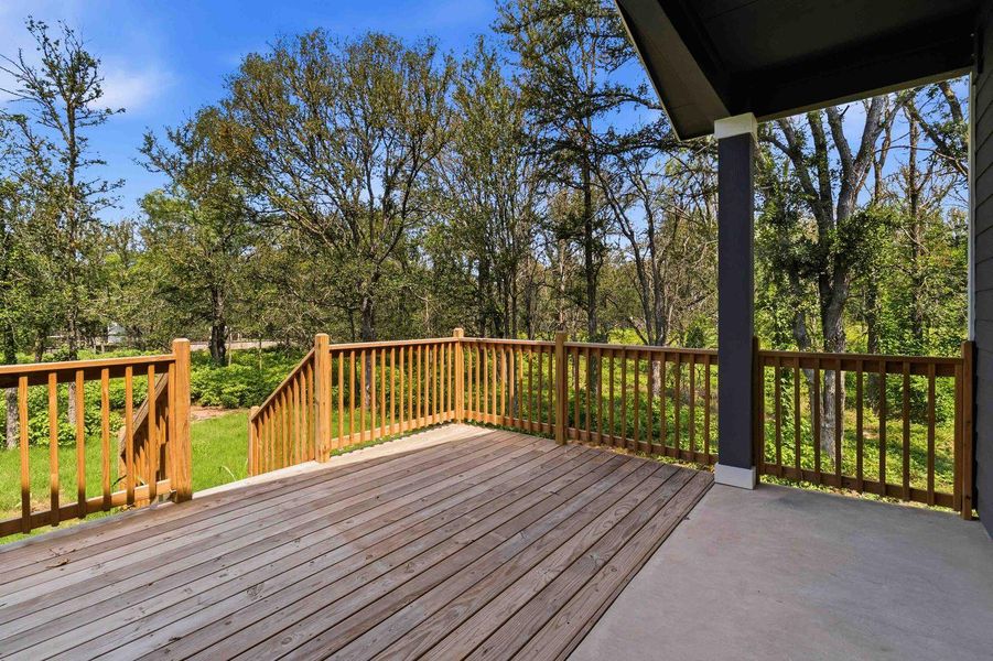 A spacious wooden deck extends into a verdant landscape, ideal for outdoor gatherings. A spacious wooden deck extends into a verdant landscape, ideal for outdoor gatherings.