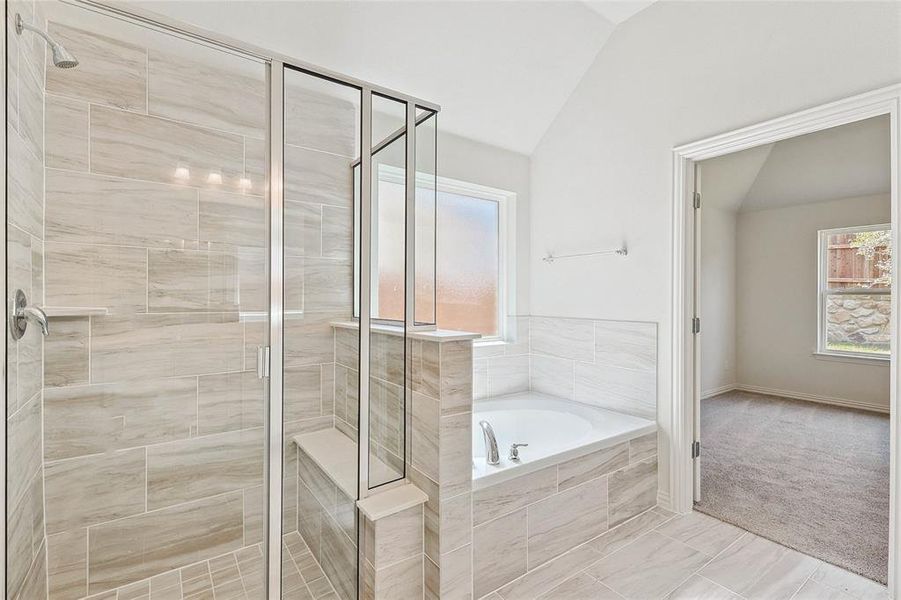 Bathroom featuring separate shower and tub, tile patterned flooring, and vaulted ceiling