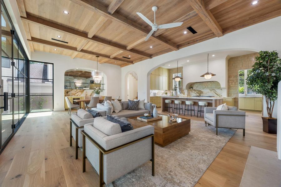 Beamed wood ceilings and light hardwood floors elevate this grand open living space.
