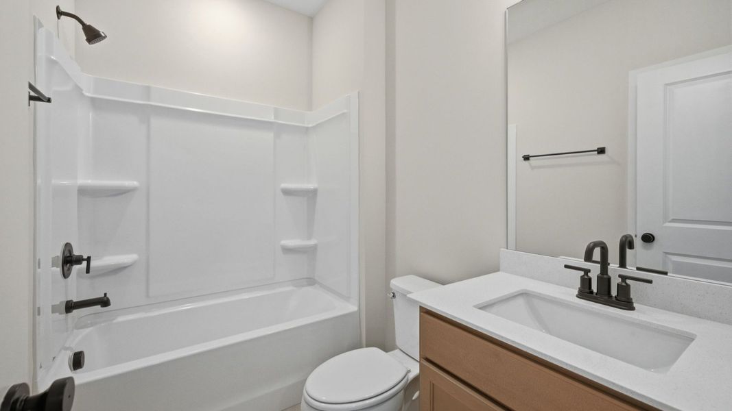 Bathroom with dual vanity, shower, and toilet