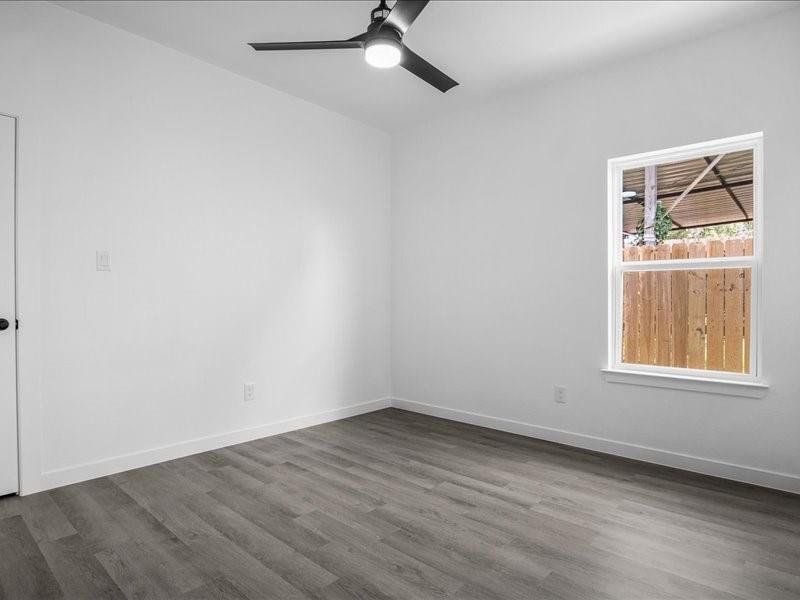 Unfurnished room with dark hardwood / wood-style floors and ceiling fan