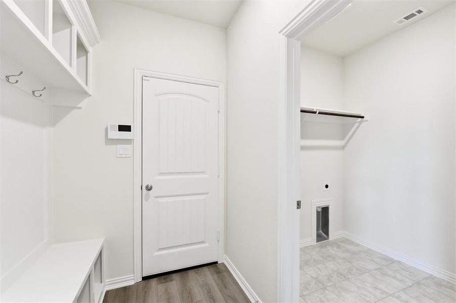 Laundry room featuring electric dryer hookup and light wood-style floors
