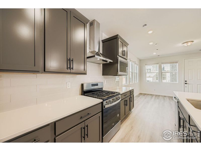 Kitchen with a gas range and chimney hood! Kitchen with a gas range and chimney hood!