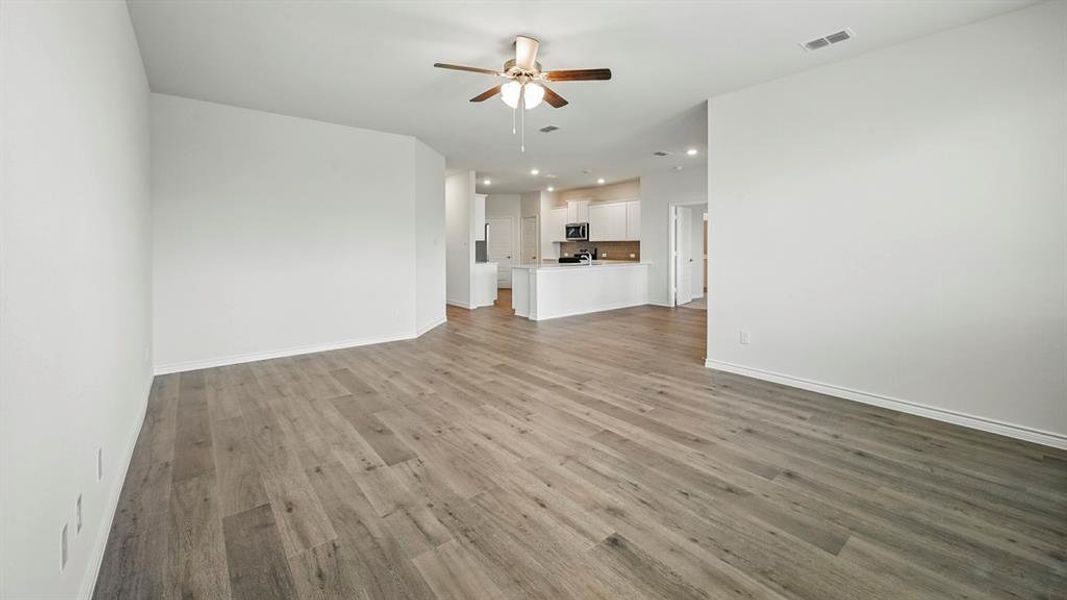 Unfurnished living room featuring light wood-style floors, a ceiling fan, and recessed lighting Unfurnished living room featuring light wood-style floors, a ceiling fan, and recessed lighting