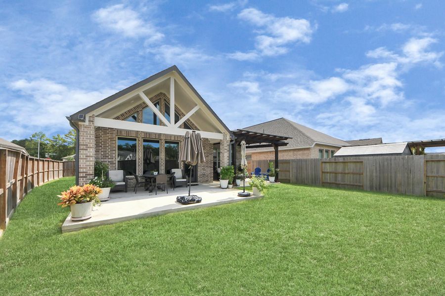 Entertainer’s DREAM backyard, with an extended patio, pergola seating, and plenty of green space.