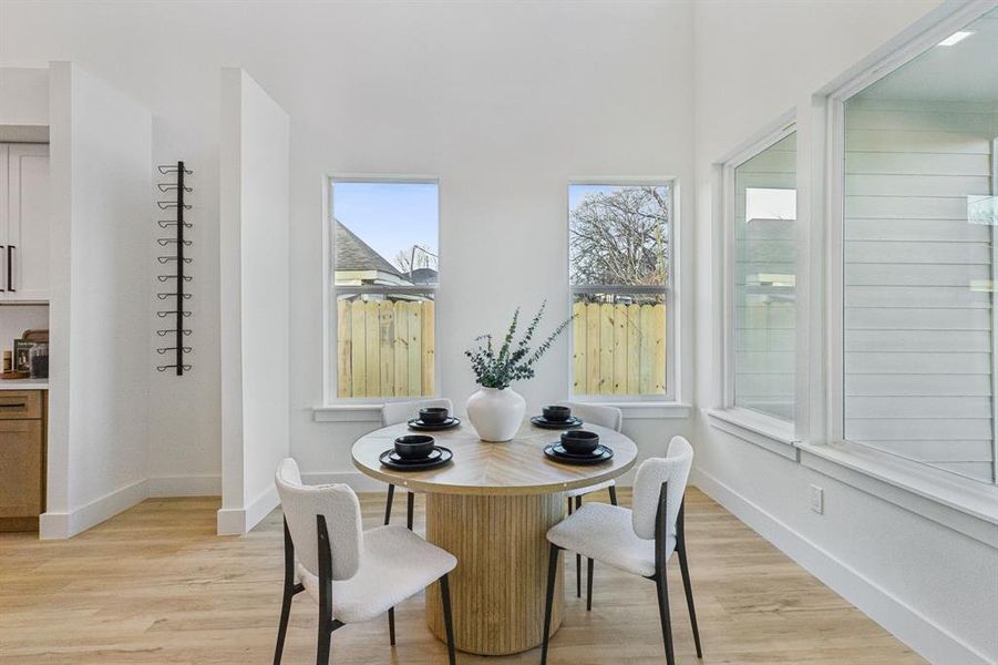 Dining space with a wealth of natural light and light wood-type flooring