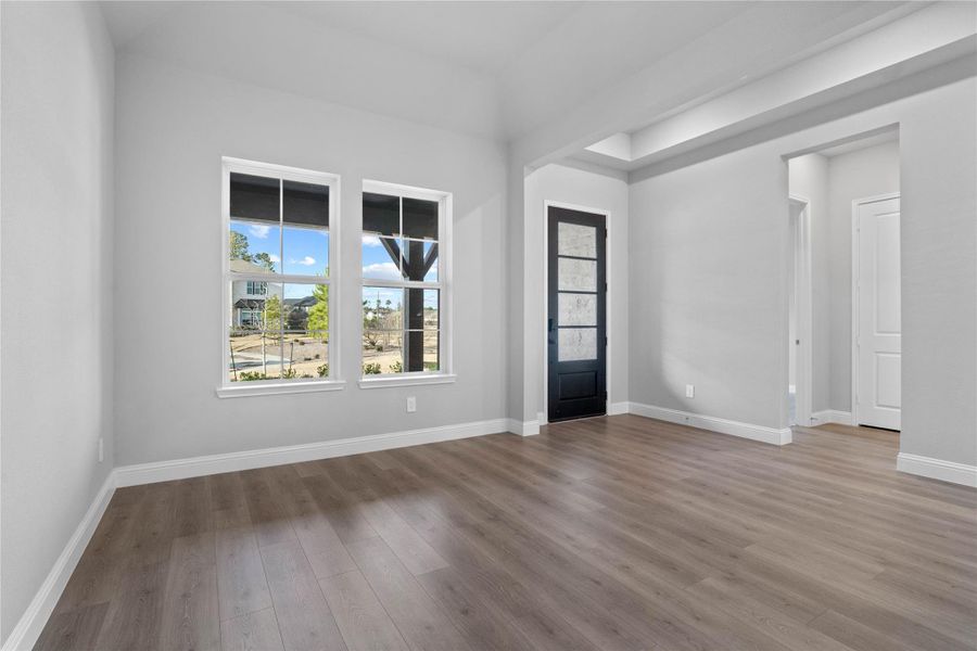 Located at the front of the home, the formal dining room creates an immediate sense of grandeur with its soaring sloped ceilings and an abundance of natural light streaming through large, energy-efficient windows.