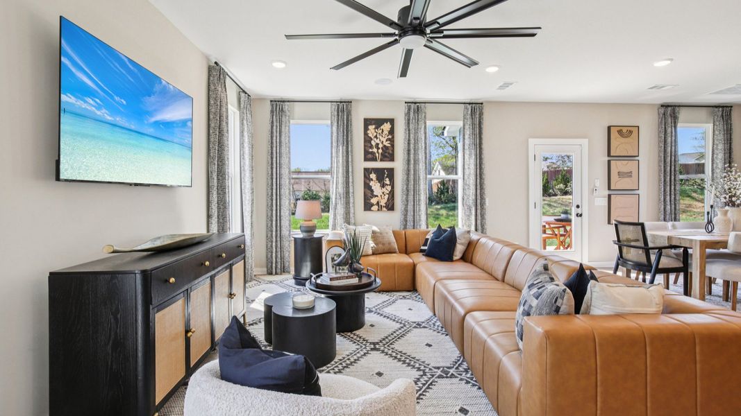 First floor living room with leather couch and large fan