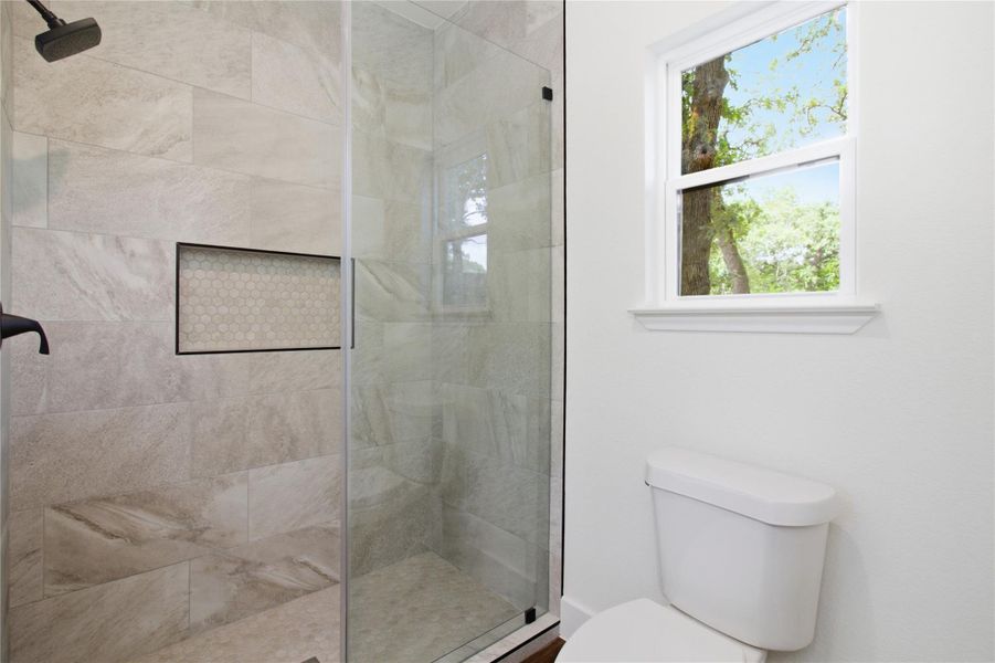 A well-lit bathroom features a spacious glass-enclosed shower with tiled walls and a functional window. A well-lit bathroom features a spacious glass-enclosed shower with tiled walls and a functional window.
