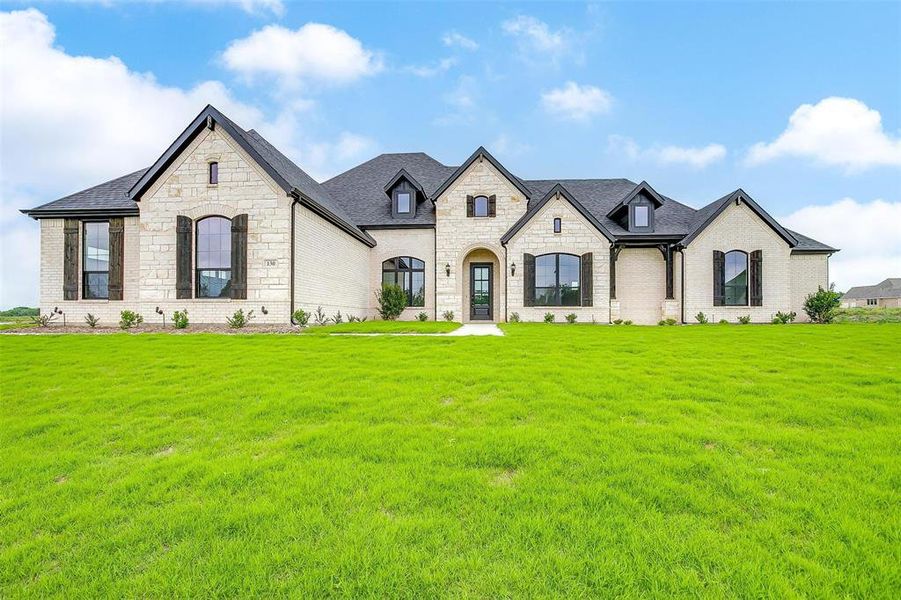 French country style house featuring a front yard