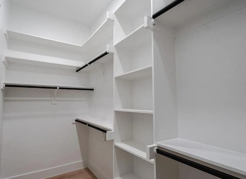 Walk in closet with light wood finished floors