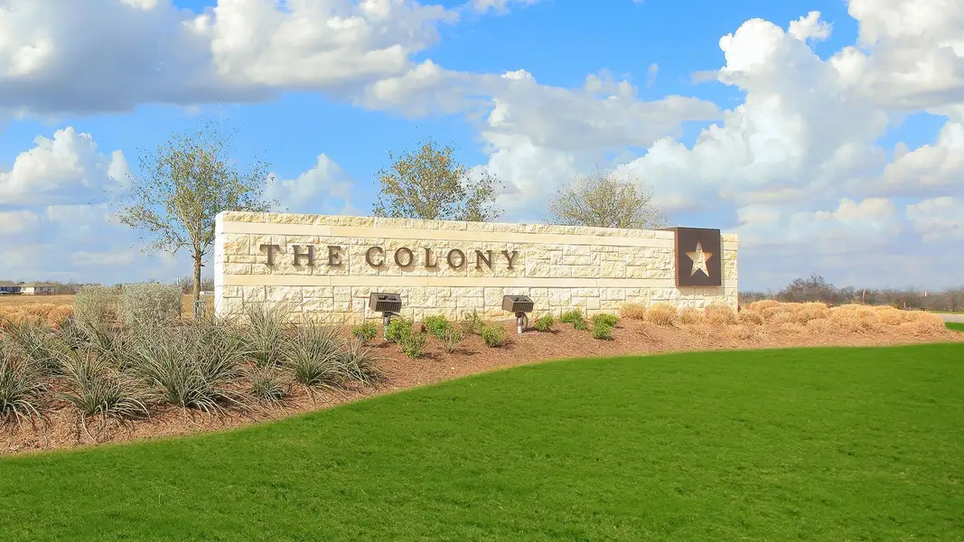 Community / neighborhood sign featuring a lawn