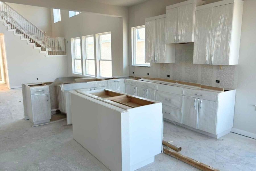 Kitchen with a kitchen island, decorative backsplash, and white cabinetry Kitchen with a kitchen island, decorative backsplash, and white cabinetry