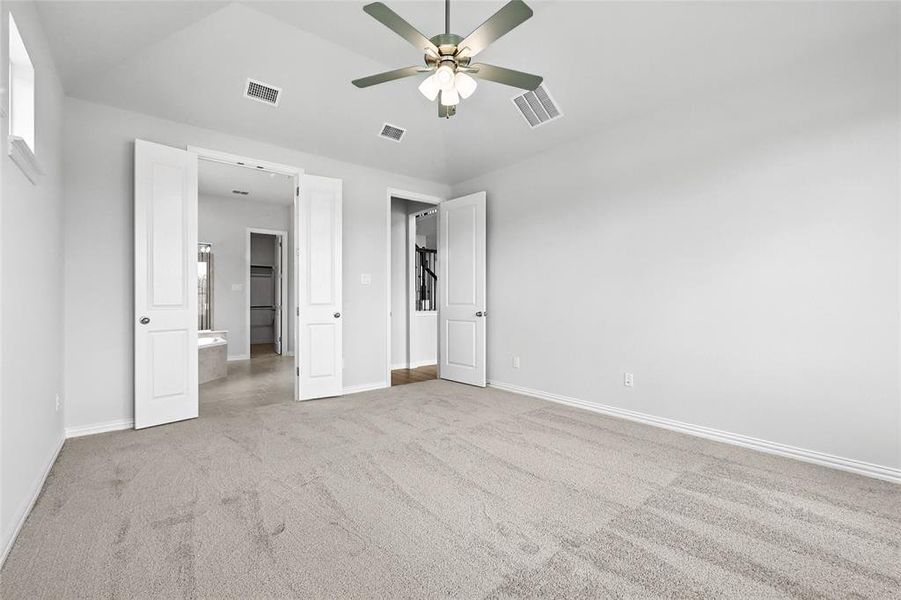 Unfurnished bedroom featuring carpet floors, lofted ceiling, and a ceiling fan Unfurnished bedroom featuring carpet floors, lofted ceiling, and a ceiling fan
