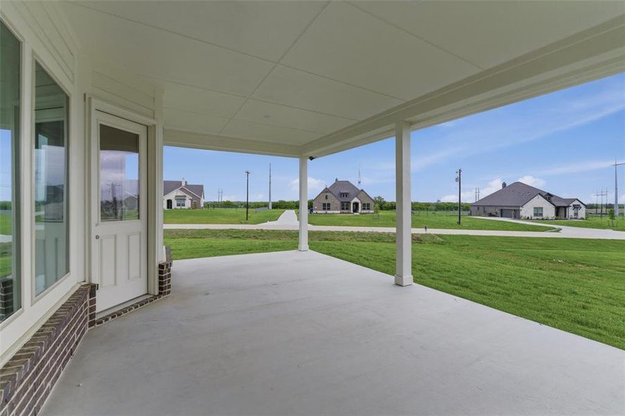 Spacious covered patio with a concrete surface and white support columns