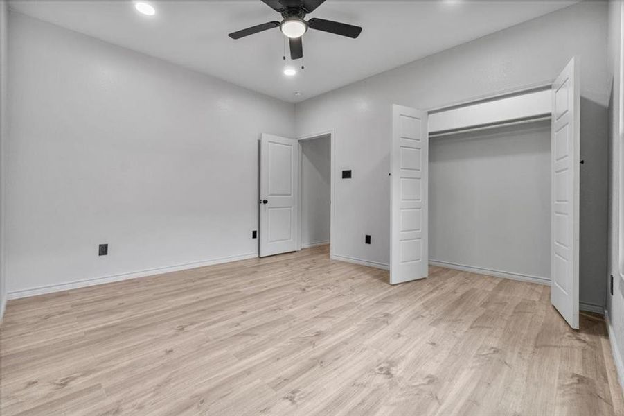 Unfurnished bedroom featuring a closet, light wood-type flooring, and ceiling fan