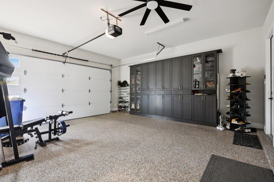 Garage featuring ceiling fan and a garage door opener