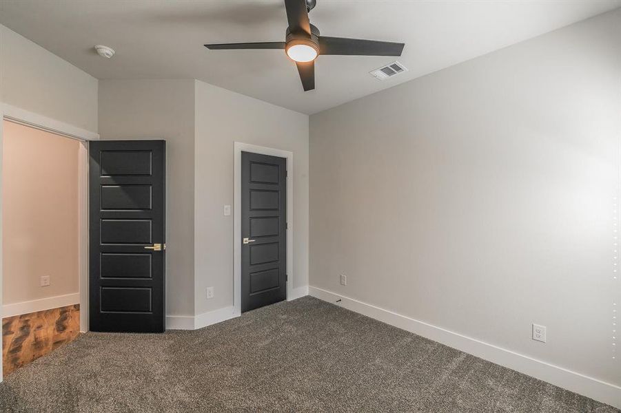 Unfurnished bedroom featuring ceiling fan and carpet floors