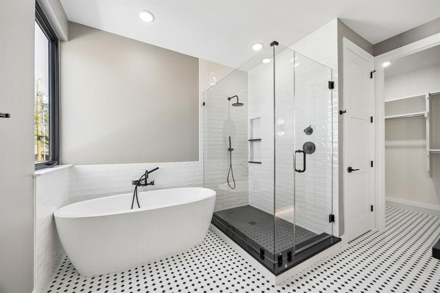 Full bath with a spacious closet, a soaking tub, a shower stall, tile walls, and recessed lighting Full bath with a spacious closet, a soaking tub, a shower stall, tile walls, and recessed lighting