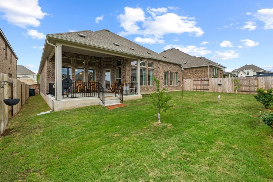 The seamless transition from the indoor living area to the covered patio makes this the ultimate setup for hosting summer cookouts or cozying up by a fire pit under the stars.