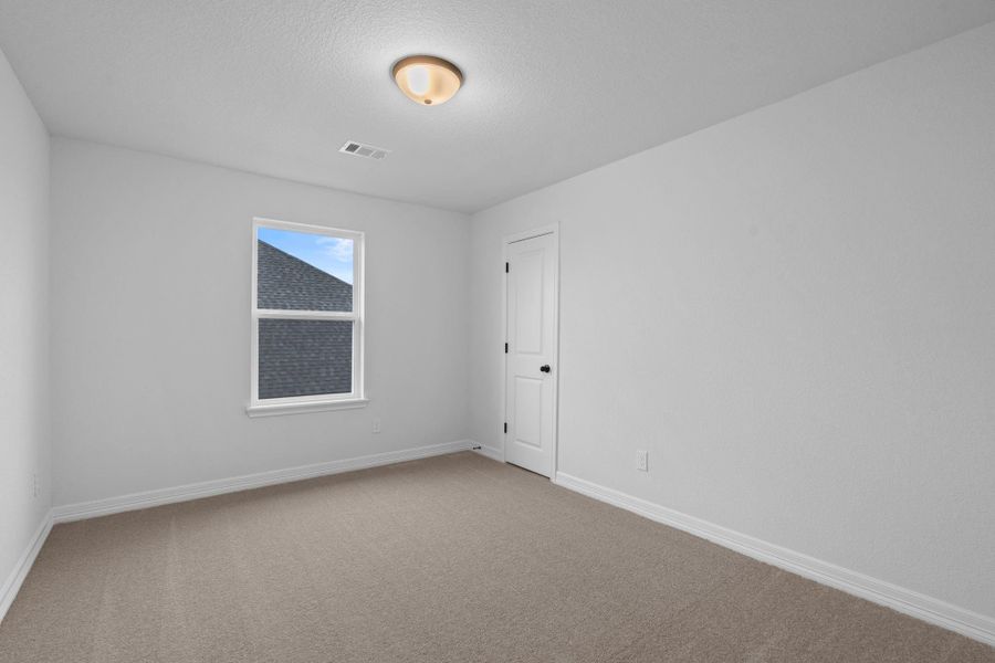 Your secondary bedroom features plush carpet, fresh paint, closet, and a large window that lets in plenty of natural lighting.