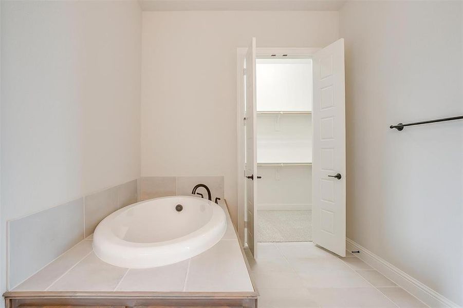 Bathroom featuring a tub to relax in and tile patterned floors